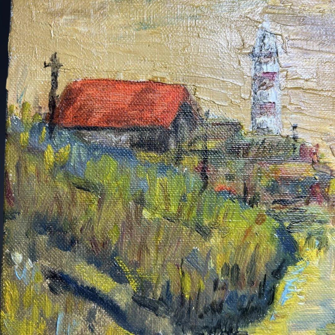 灯台と赤い屋根の建物が描かれた油彩画